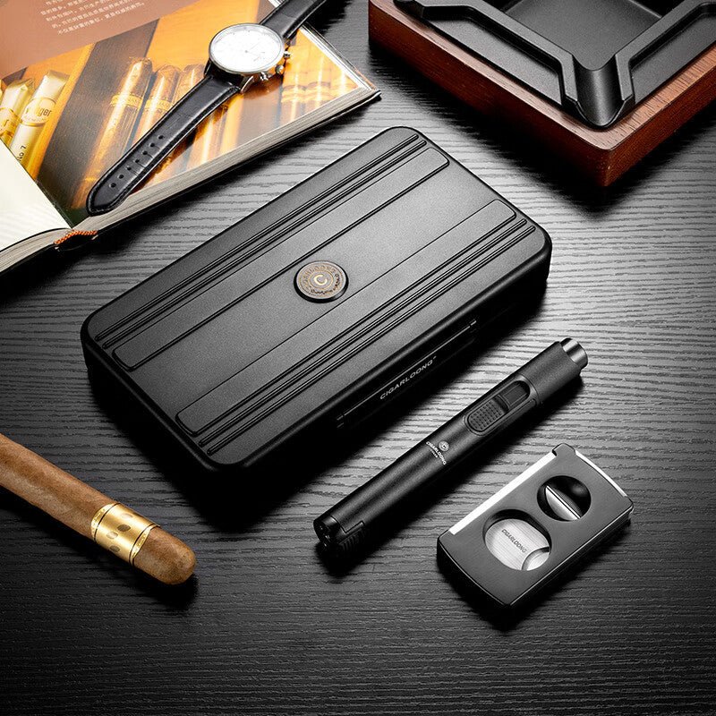 Offrir un cigare en cadeau, coffret fumeur en métal posé sur un bureau en bois avec montre, magazine cigare, cendrier bois et briquet torche